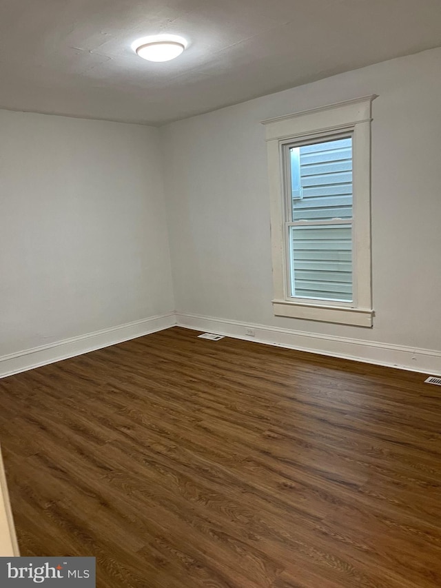 spare room with dark wood-type flooring