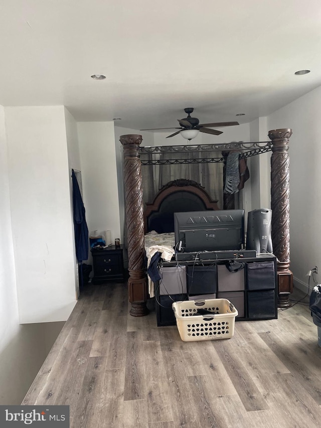 bedroom with a fireplace, ceiling fan, and hardwood / wood-style flooring