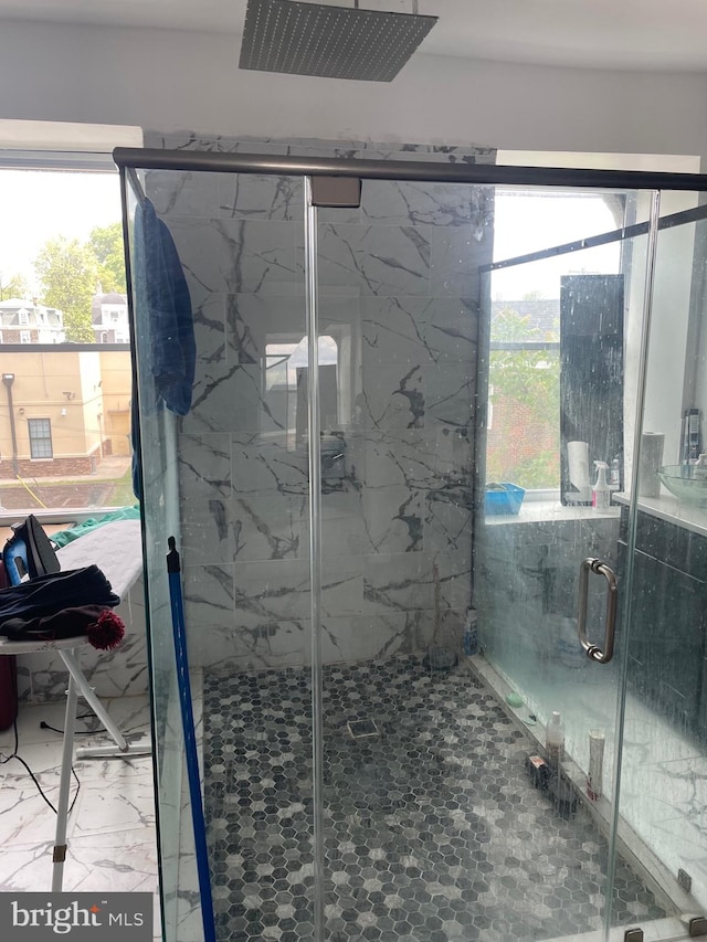 bathroom featuring a healthy amount of sunlight, tile floors, and a shower with door