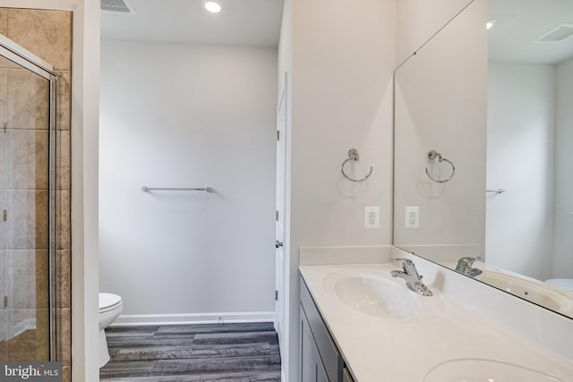 bathroom with walk in shower, large vanity, toilet, hardwood / wood-style floors, and dual sinks