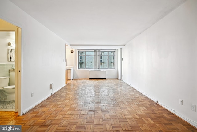 empty room with radiator heating unit and light parquet flooring