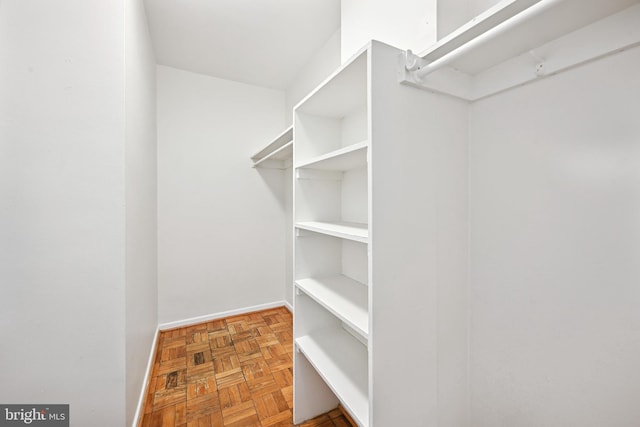 walk in closet featuring parquet flooring