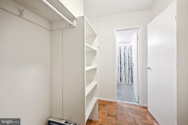 spacious closet featuring parquet flooring