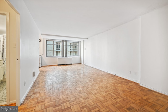 spare room with light parquet flooring and radiator