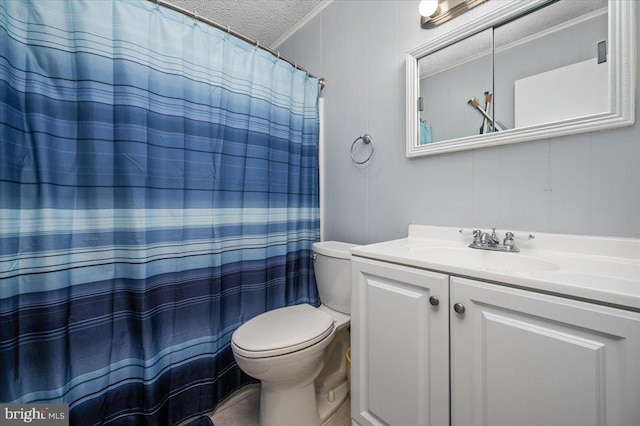 bathroom featuring a textured ceiling, oversized vanity, and toilet