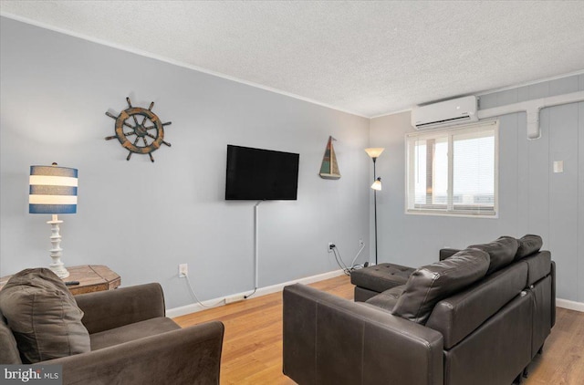 living room with a textured ceiling, hardwood / wood-style floors, and a wall mounted air conditioner