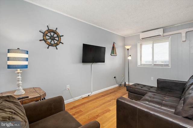 living room with a wall unit AC, ornamental molding, a textured ceiling, and hardwood / wood-style floors