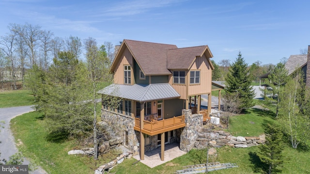 rear view of property with a patio area, a yard, and a wooden deck