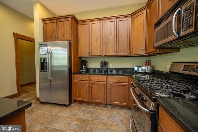 kitchen with stainless steel appliances and dark stone counters