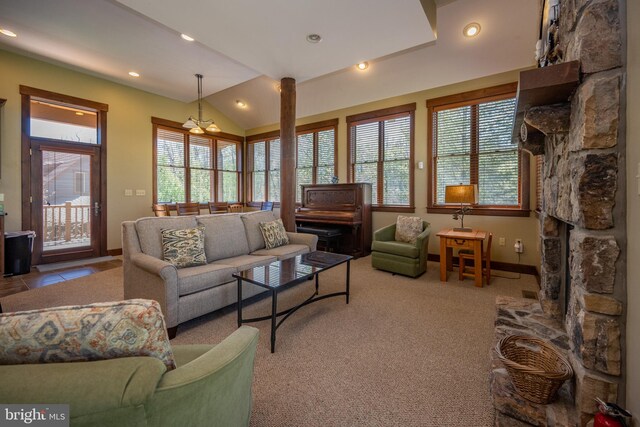 living room featuring a stone fireplace, light carpet, vaulted ceiling, and a notable chandelier