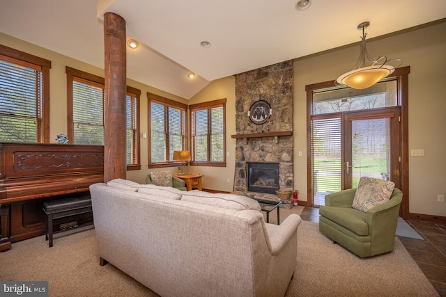 living room with a healthy amount of sunlight, a stone fireplace, and lofted ceiling