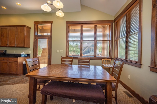 carpeted dining room with lofted ceiling and a healthy amount of sunlight