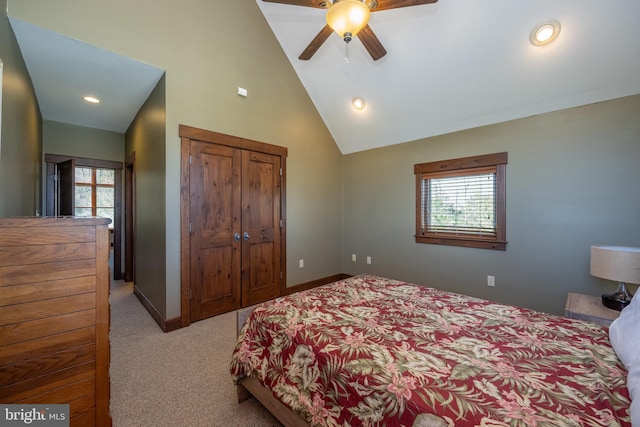 carpeted bedroom featuring a closet, high vaulted ceiling, multiple windows, and ceiling fan