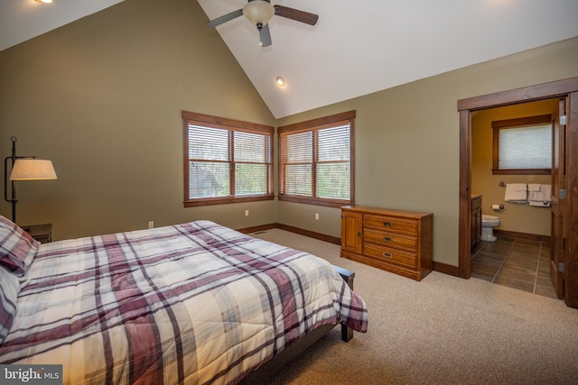 carpeted bedroom with ensuite bathroom, high vaulted ceiling, and ceiling fan