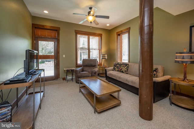 carpeted living room with ceiling fan and a baseboard radiator