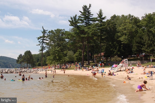 view of community with a water view and a beach view