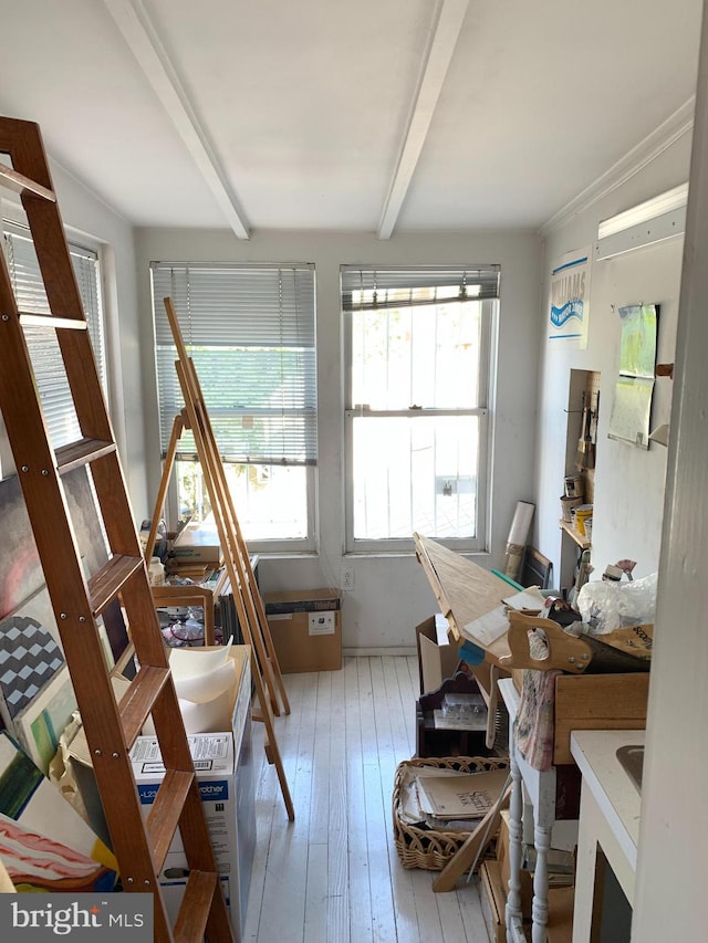 miscellaneous room with beam ceiling and wood-type flooring