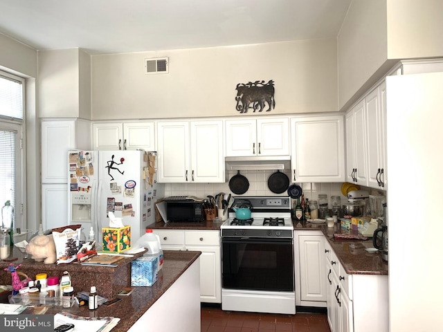 kitchen with decorative backsplash, white cabinetry, white refrigerator with ice dispenser, and range with gas stovetop