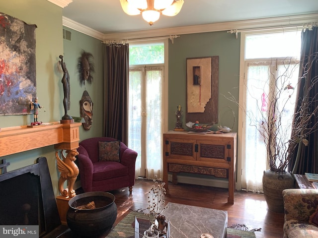 living room featuring ornamental molding, hardwood / wood-style flooring, and a notable chandelier