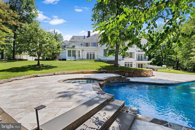 view of swimming pool with an in ground hot tub, a patio, and a lawn