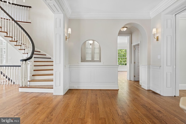 foyer with hardwood / wood-style flooring and crown molding