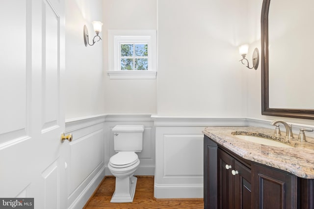 bathroom with hardwood / wood-style floors, vanity, and toilet