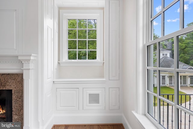 entryway featuring a high end fireplace, hardwood / wood-style flooring, and a wealth of natural light