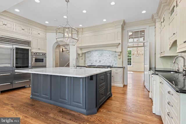 kitchen featuring crown molding, hardwood / wood-style floors, and hanging light fixtures