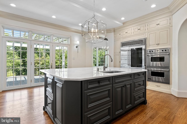 kitchen featuring sink, a healthy amount of sunlight, a center island with sink, and appliances with stainless steel finishes