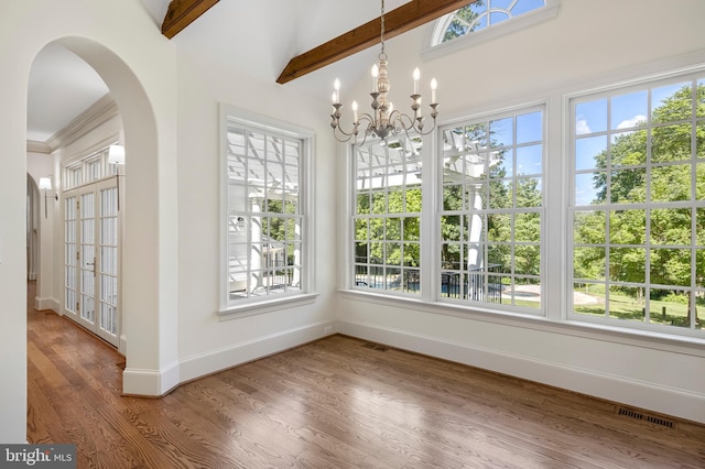 interior space with lofted ceiling with beams and a chandelier