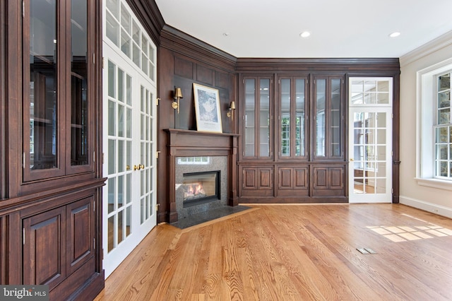 entrance foyer with french doors, crown molding, and light hardwood / wood-style flooring