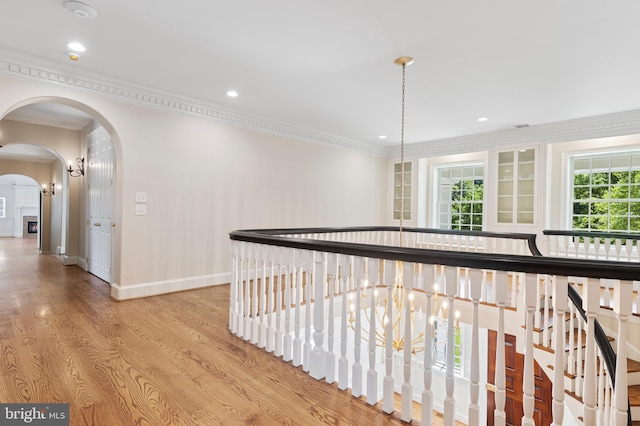 hall featuring light wood-type flooring and crown molding