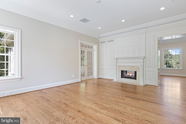 unfurnished living room with light hardwood / wood-style flooring and french doors