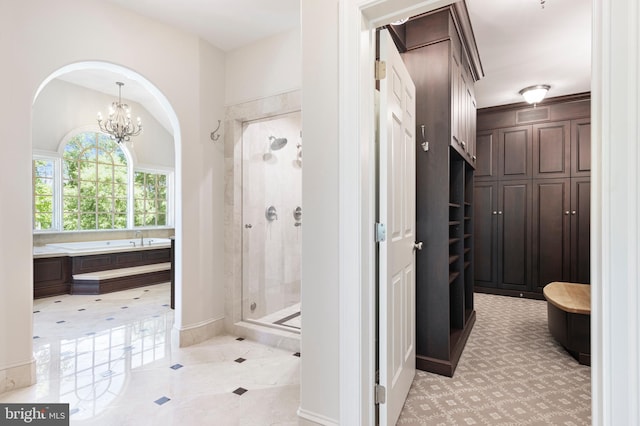 bathroom featuring tile patterned flooring, separate shower and tub, and an inviting chandelier