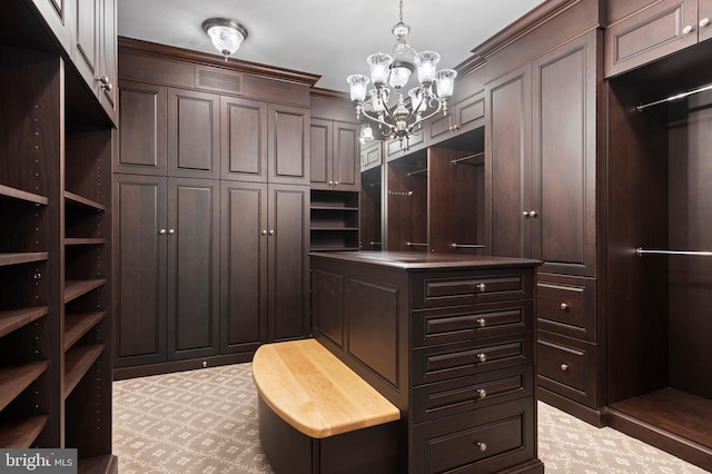 spacious closet with light colored carpet and a notable chandelier