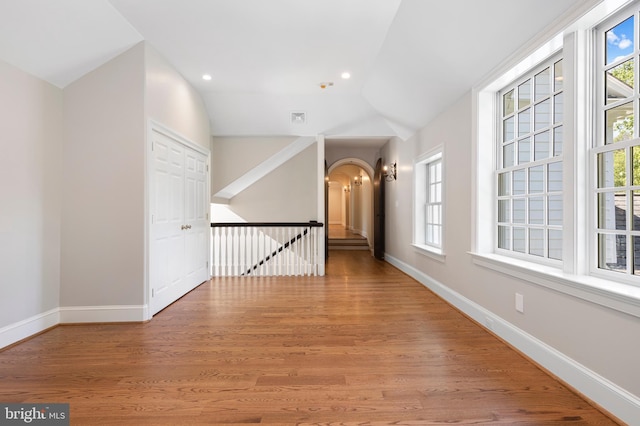 hallway featuring hardwood / wood-style floors and vaulted ceiling