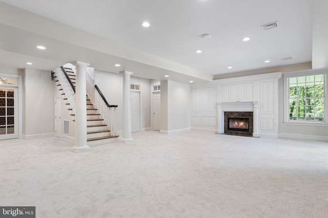 unfurnished living room with a high end fireplace and light colored carpet