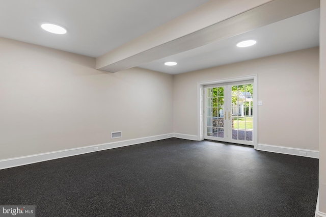 empty room with beamed ceiling and french doors