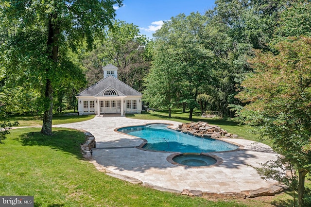 view of swimming pool featuring an outbuilding, a patio area, a yard, and an in ground hot tub