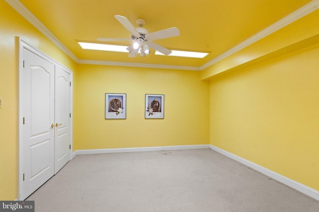 carpeted empty room featuring ceiling fan and crown molding