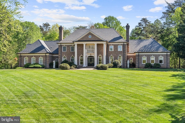 neoclassical / greek revival house with a balcony and a front lawn