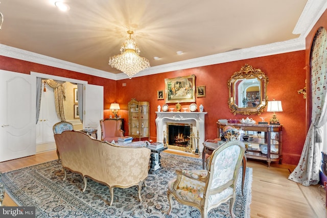 living room featuring light hardwood / wood-style floors, an inviting chandelier, and crown molding