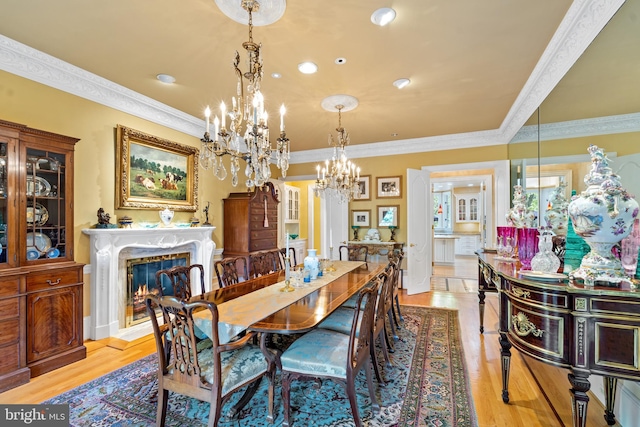 dining room featuring crown molding, light hardwood / wood-style flooring, and a premium fireplace