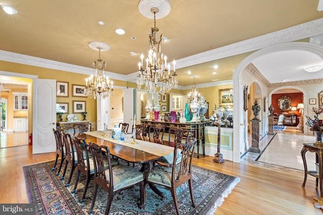 dining room with crown molding and light hardwood / wood-style flooring