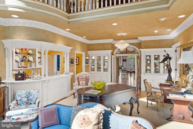 dining area with a chandelier, a towering ceiling, decorative columns, and ornamental molding