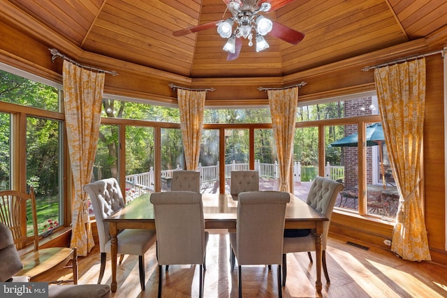 dining area featuring a towering ceiling, light hardwood / wood-style floors, ceiling fan, and wood ceiling