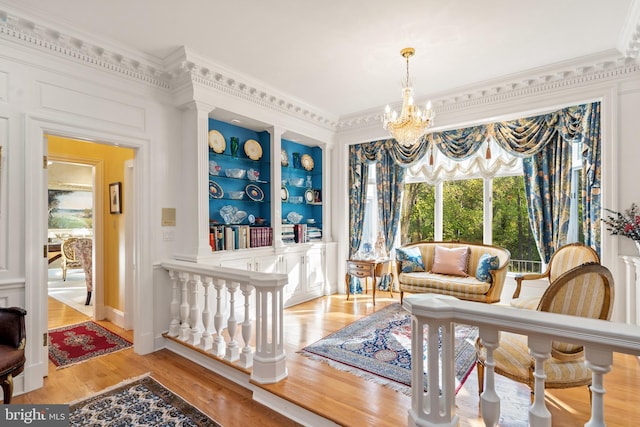 interior space featuring an inviting chandelier, crown molding, and light hardwood / wood-style flooring