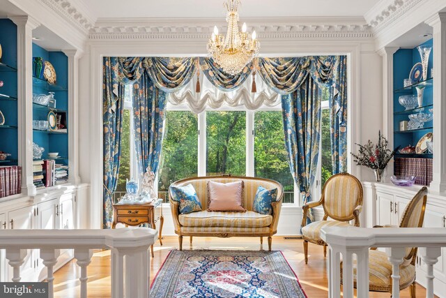 bedroom featuring a notable chandelier, crown molding, and light hardwood / wood-style flooring