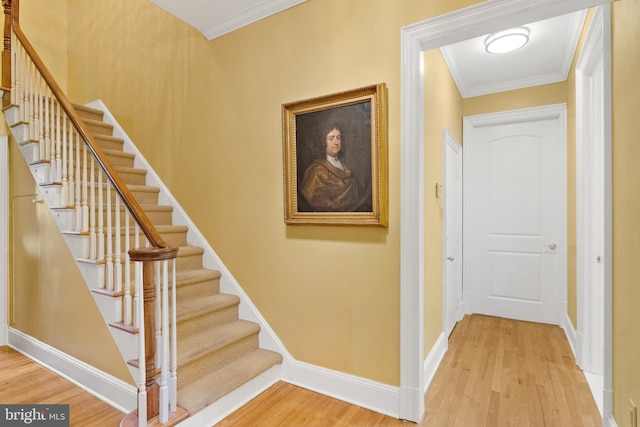 stairway with hardwood / wood-style flooring and ornamental molding