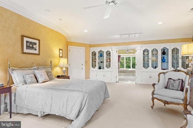 carpeted bedroom featuring track lighting, ceiling fan, and ornamental molding